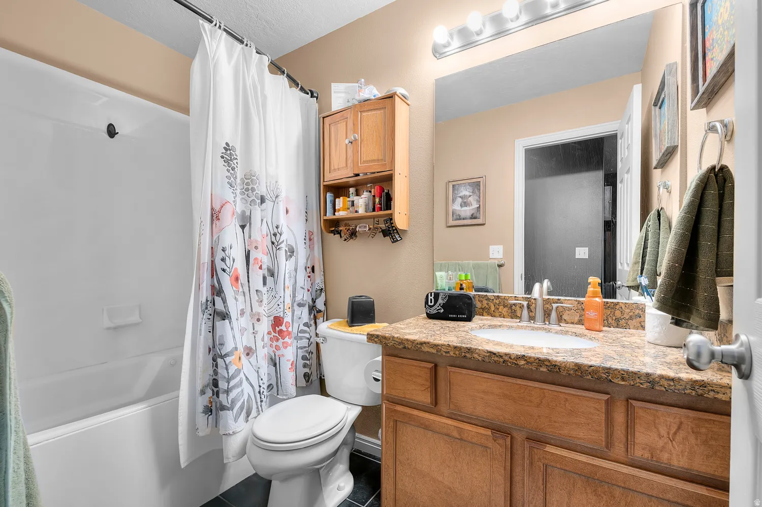 Bathroom featuring vanity and shower / tub combo with curtain