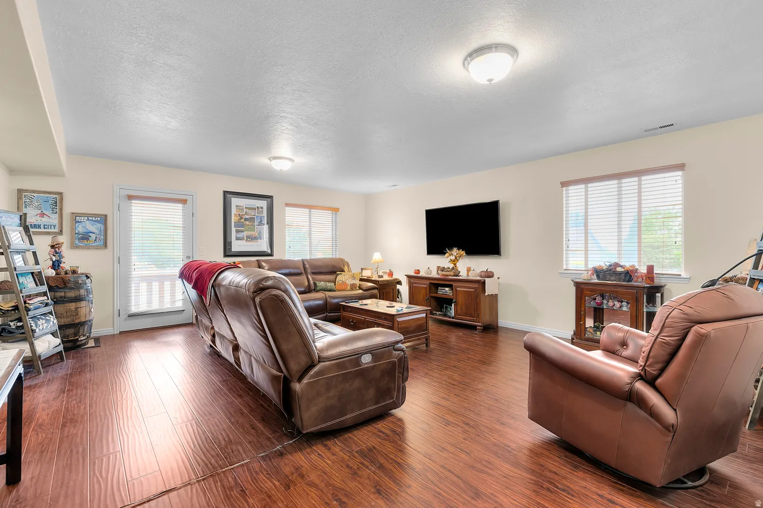 Living room featuring dark wood-style flooring and a textured ceiling