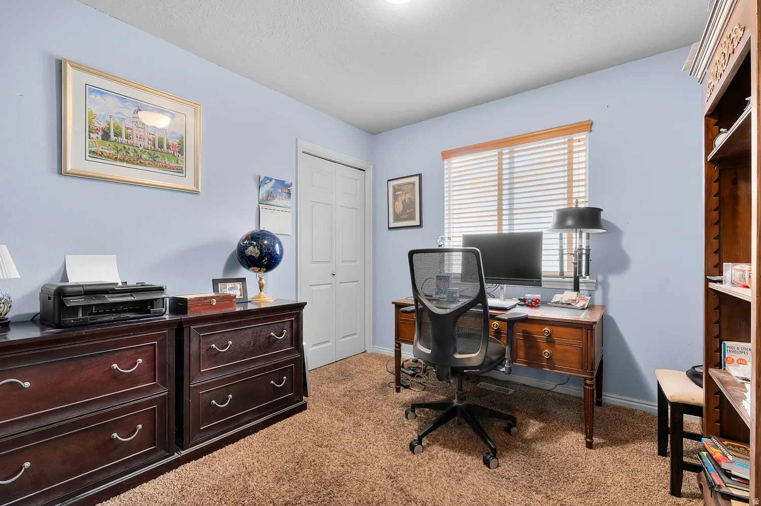 Office with light colored carpet and a textured ceiling