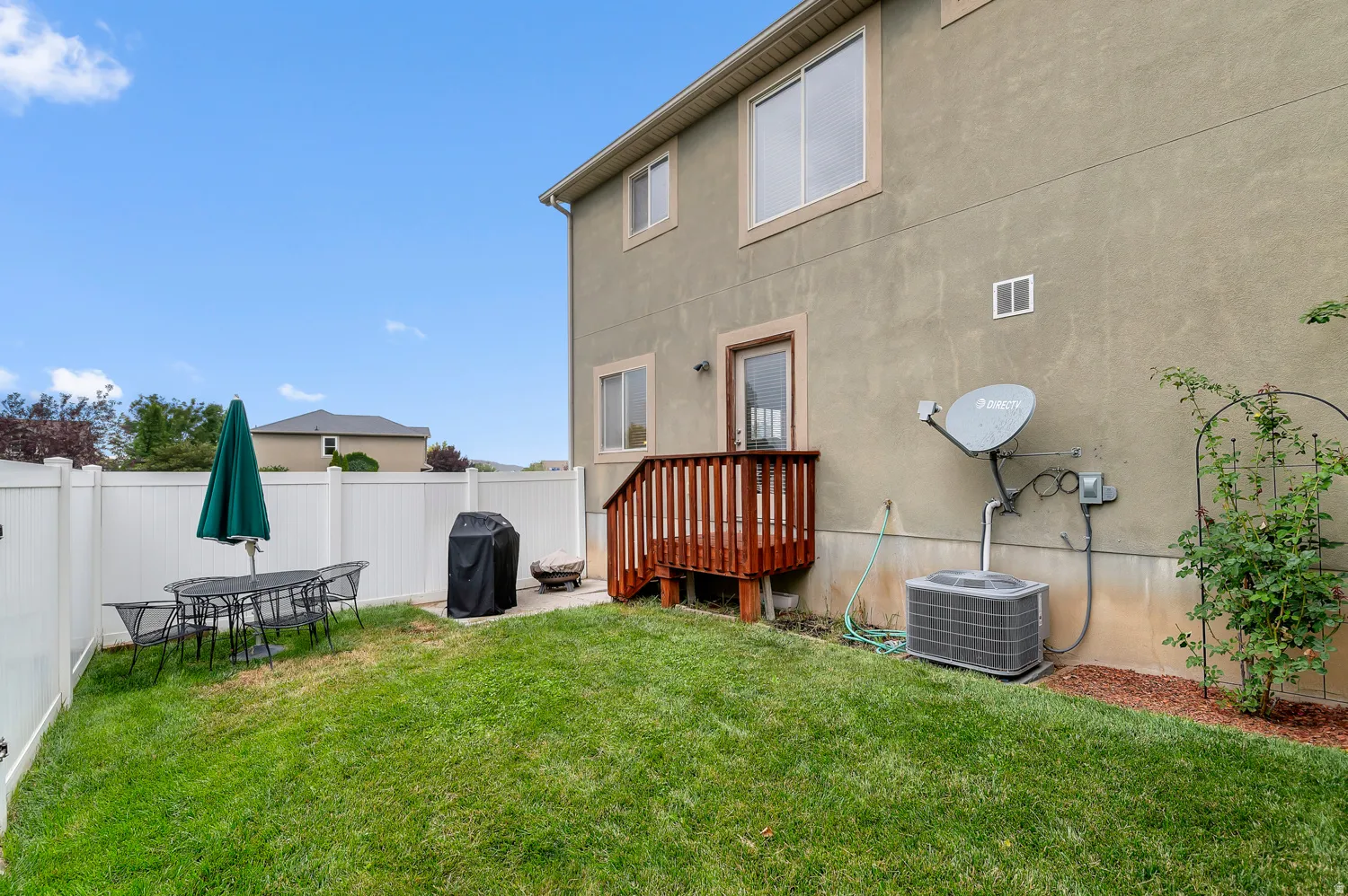 Back of property featuring stucco siding, a fenced backyard, outdoor dining area, and a patio