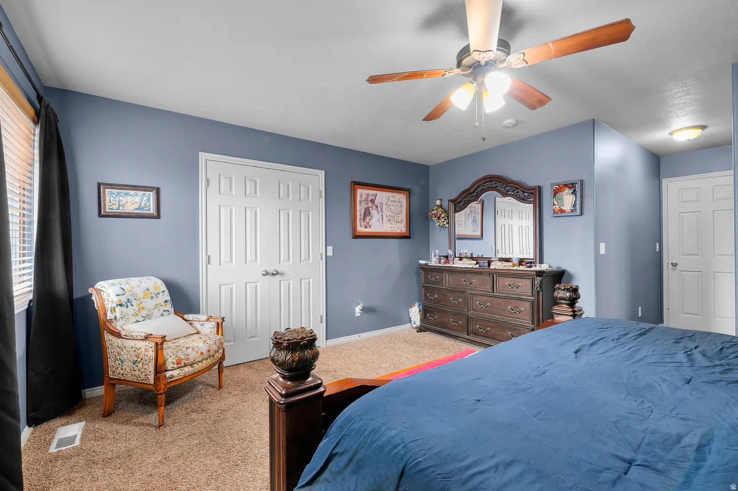 Carpeted bedroom featuring a closet and a ceiling fan
