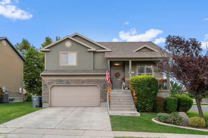 View of front of home featuring a garage, stucco siding, concrete driveway, covered porch, and roof with shingles