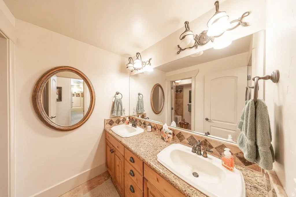 Full bath with double vanity and baseboards
