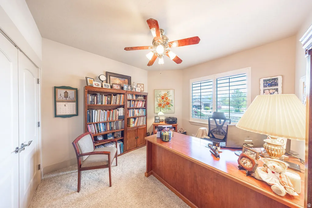 Office space featuring ceiling fan and light carpet