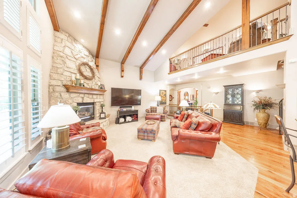Living room featuring a fireplace, plenty of natural light, wood finished floors, recessed lighting, and lofted ceiling
