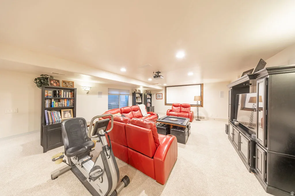 Living area with light carpet and recessed lighting