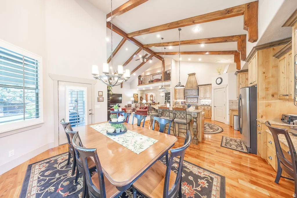 Dining area with light wood-style floors and lofted ceiling