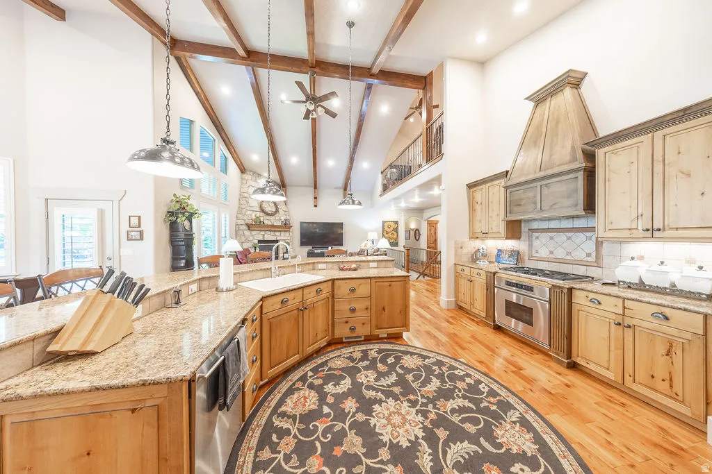 Kitchen with light stone counters, a breakfast bar, a ceiling fan, decorative light fixtures, and open floor plan
