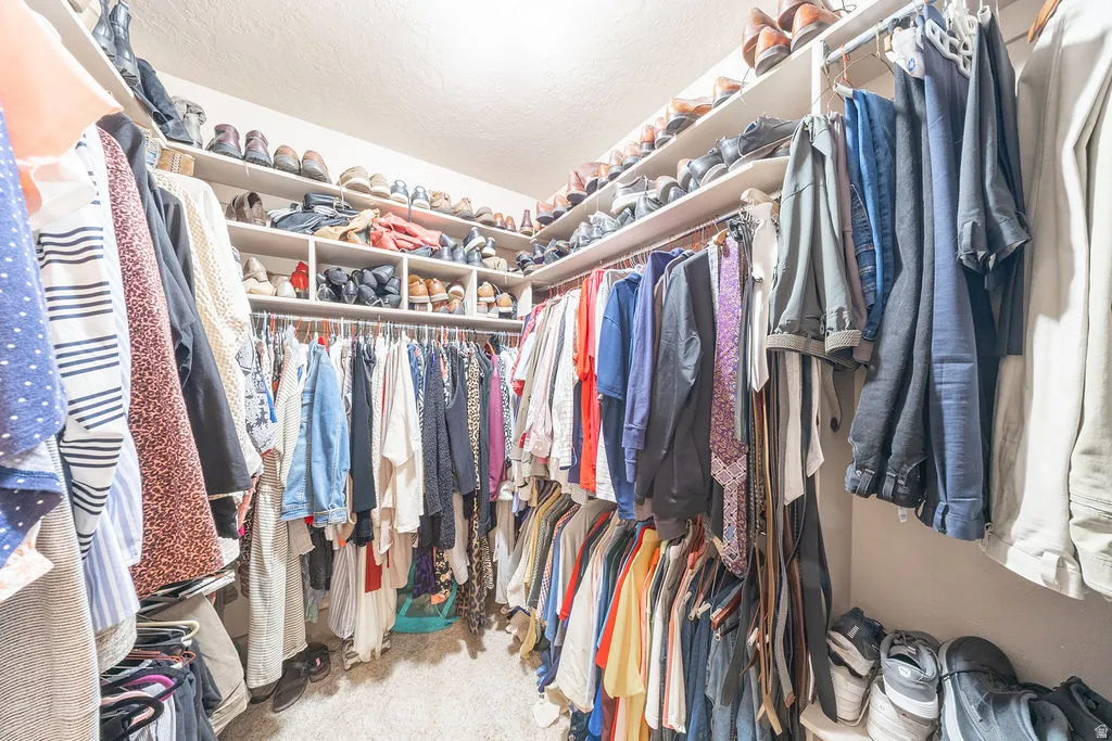 Walk in closet featuring light colored carpet