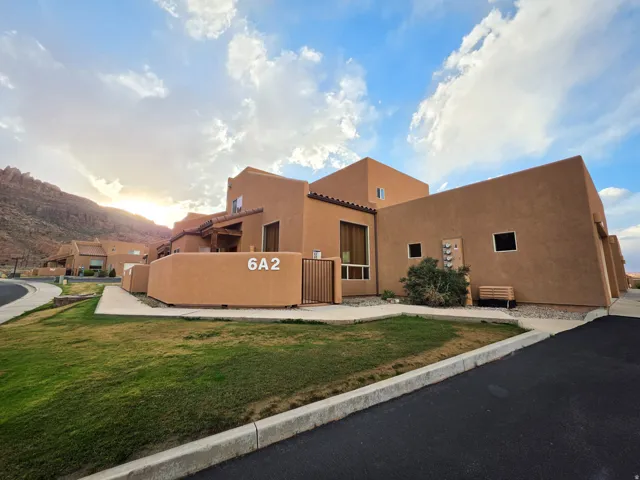 View of front of property with stucco siding, a front yard, a mountain view, and a tile roof