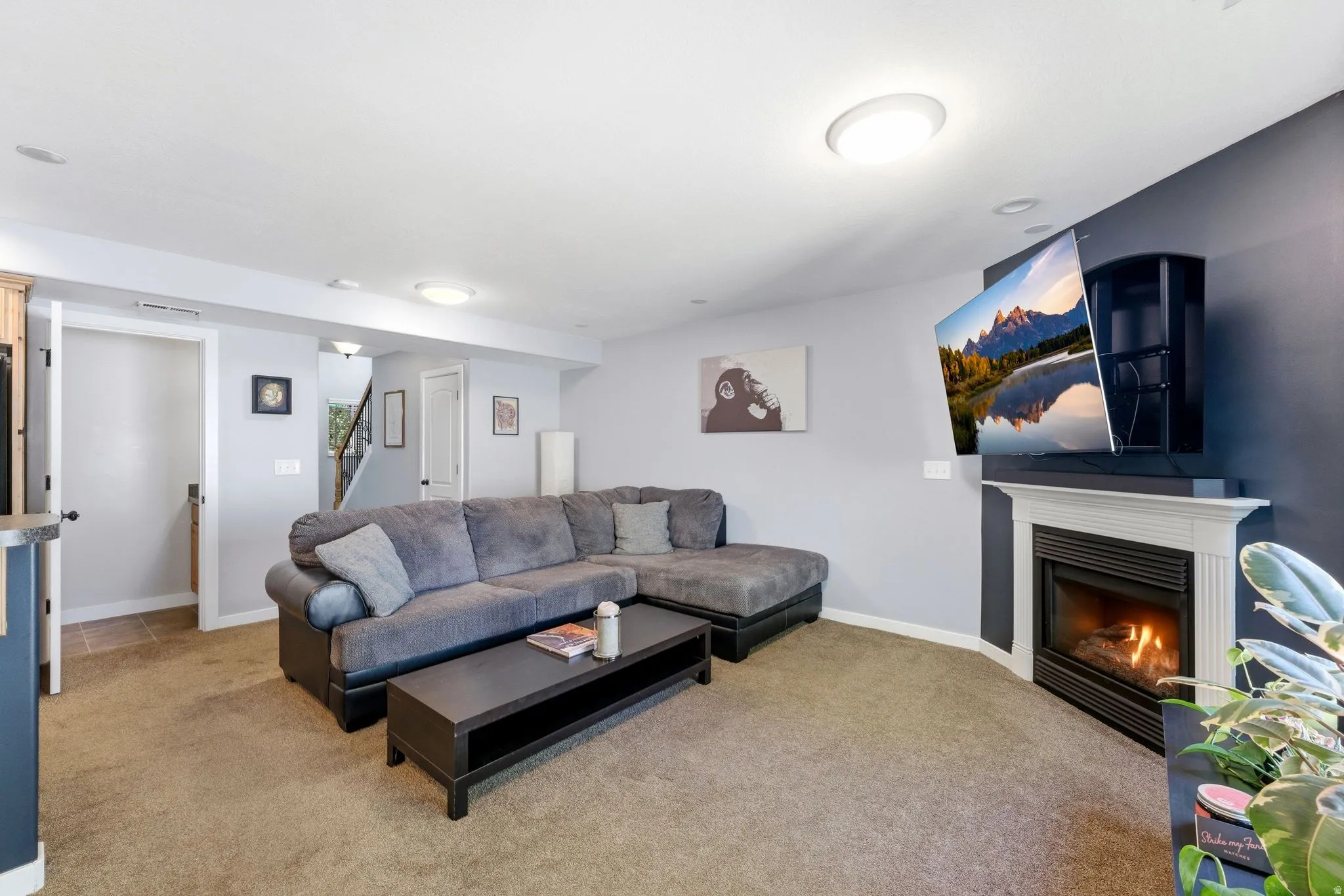 Living area featuring a glass covered fireplace and light carpet