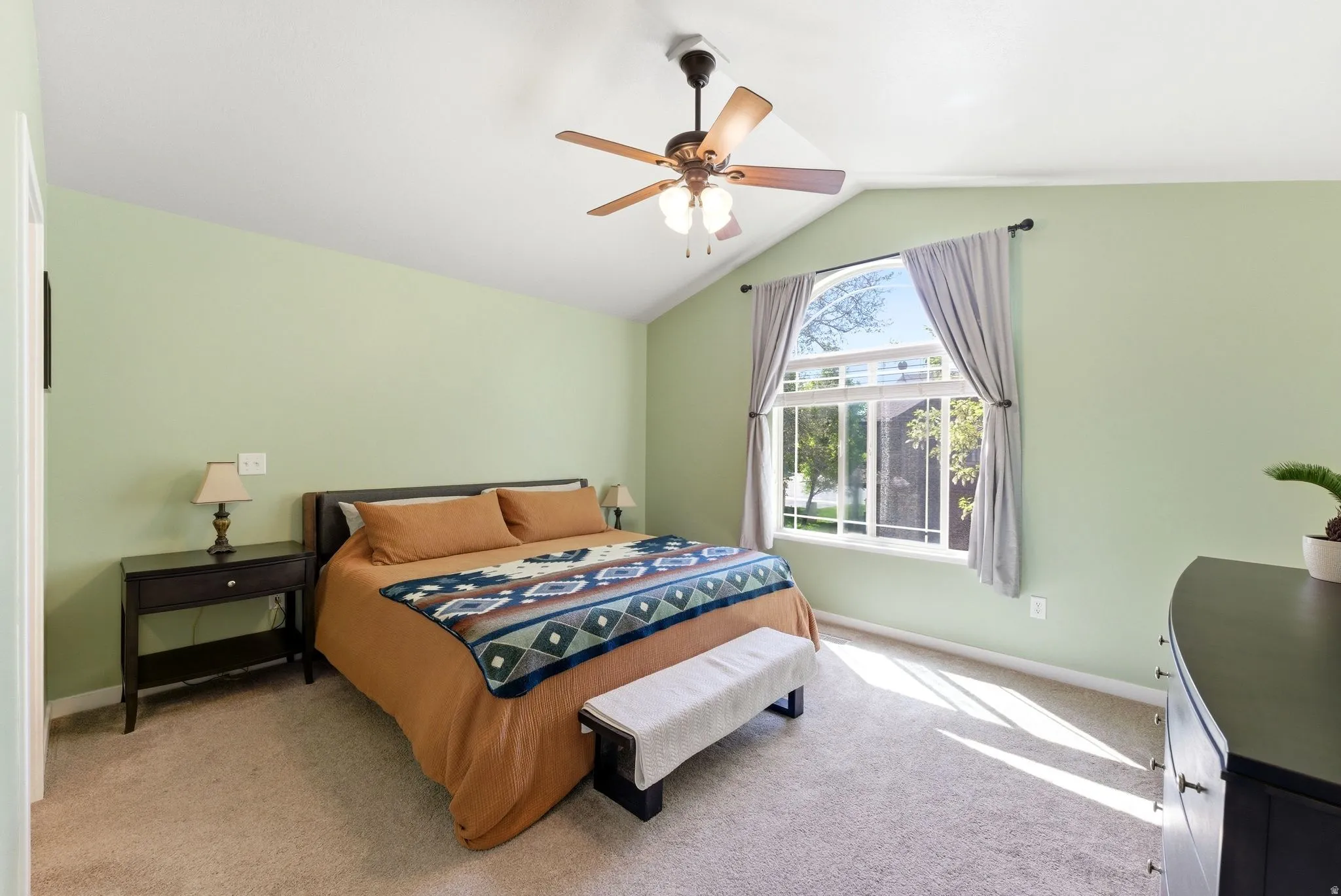 Bedroom with light carpet, lofted ceiling, and a ceiling fan