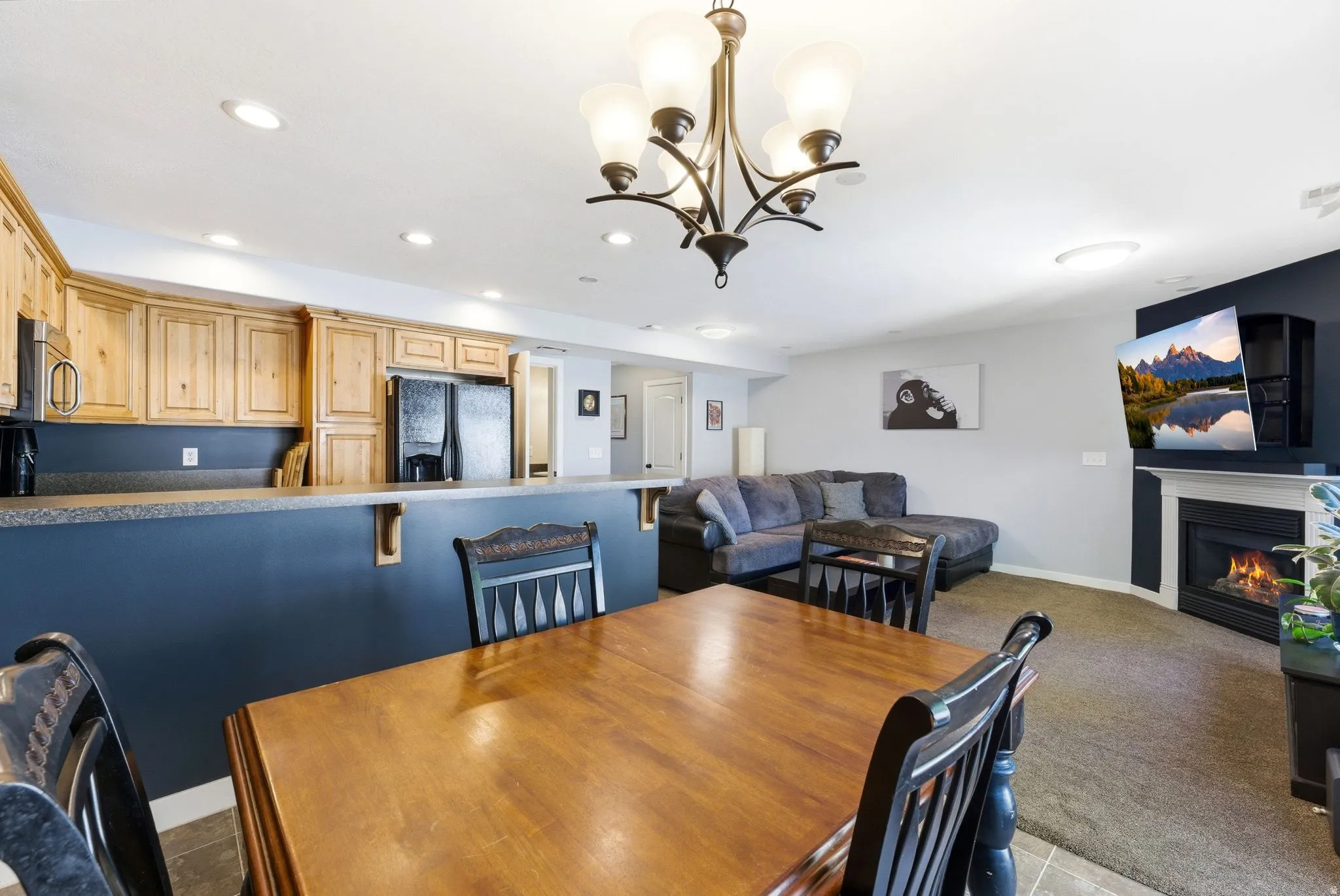 Dining area with a glass covered fireplace, carpet flooring, and a chandelier