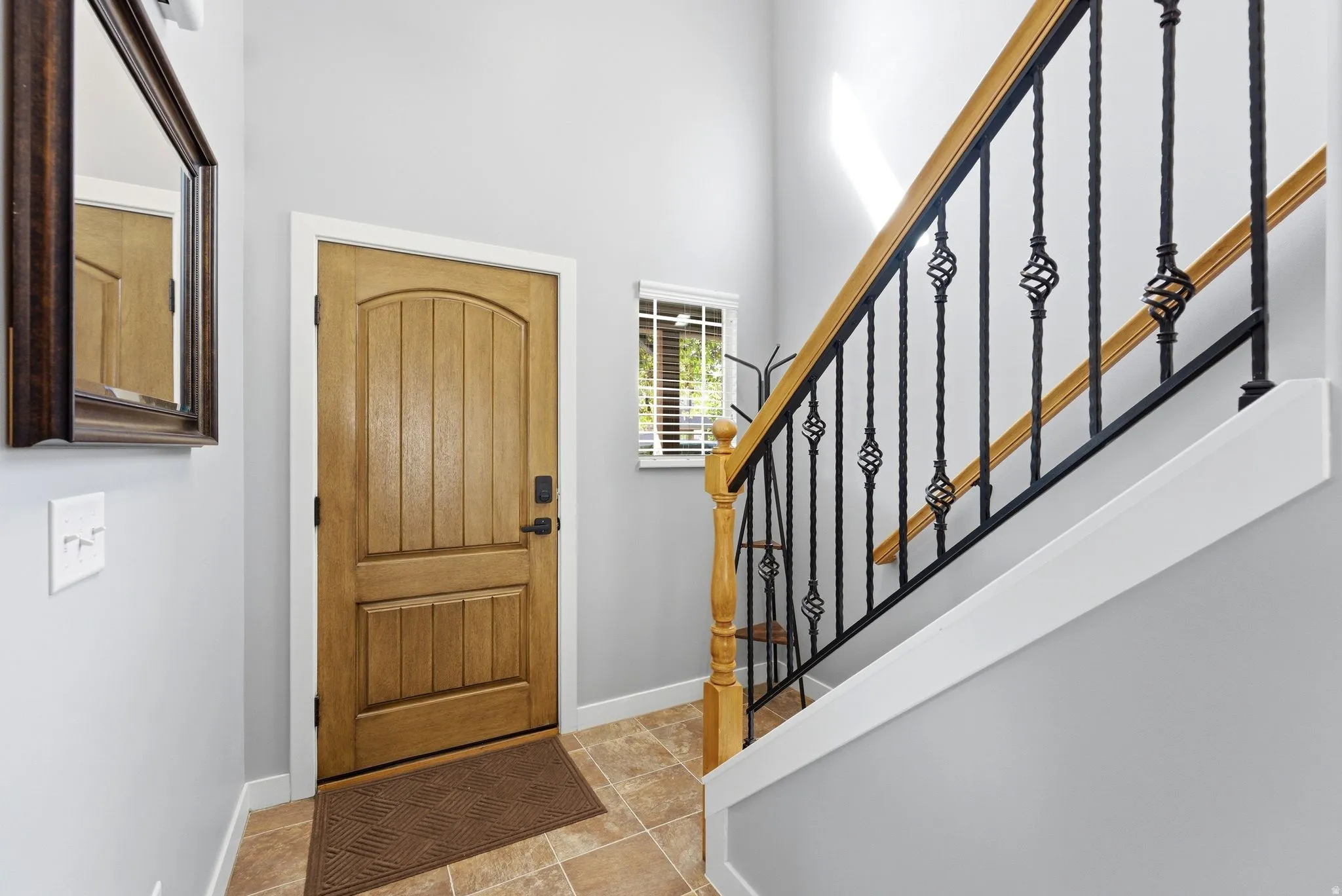 Foyer with stairway and light tile patterned flooring