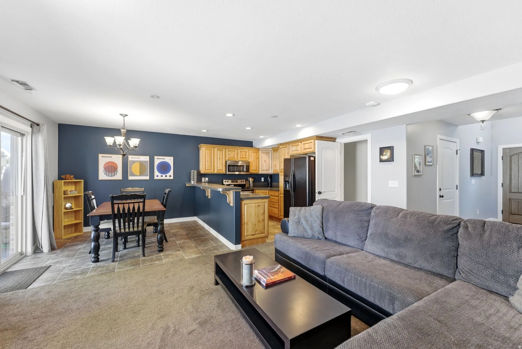 Living area featuring hanging lights and light carpet