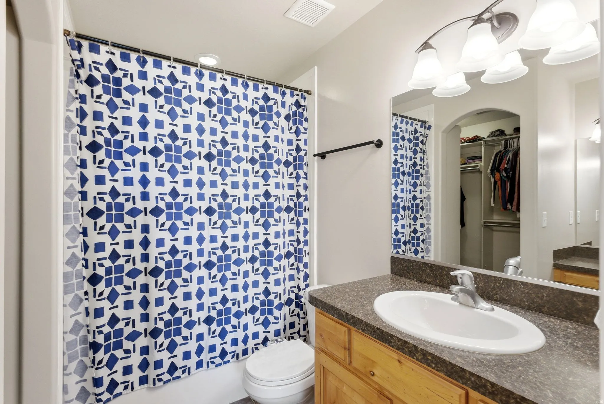 Bathroom with vanity and a spacious closet