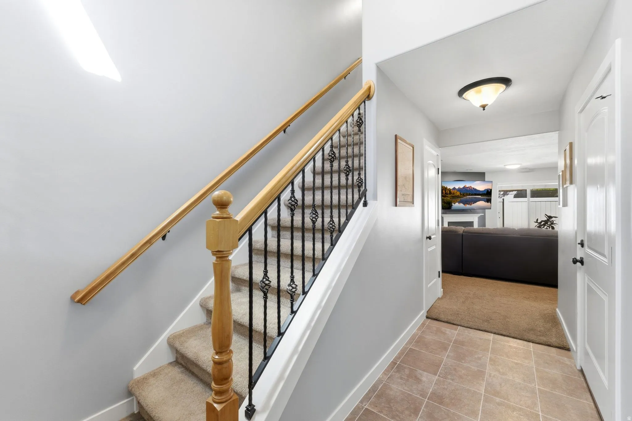 Stairway featuring tile patterned flooring and carpet flooring