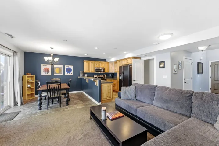 Living area featuring hanging lights and light carpet