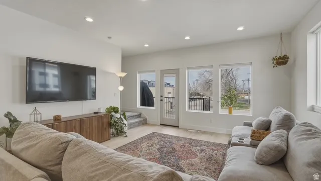 Living area featuring light wood-style floors, recessed lighting, and plenty of natural light