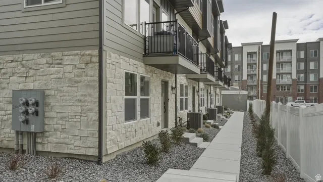 View of side of property with stone siding and a balcony