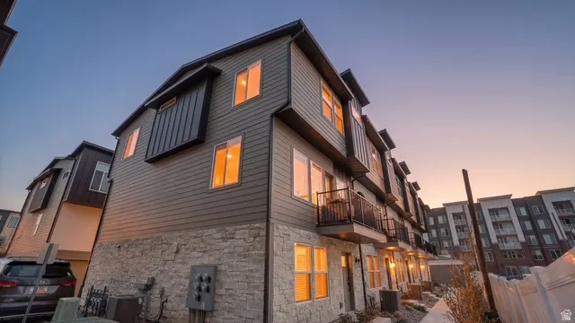 View of home's exterior featuring stone siding and a balcony
