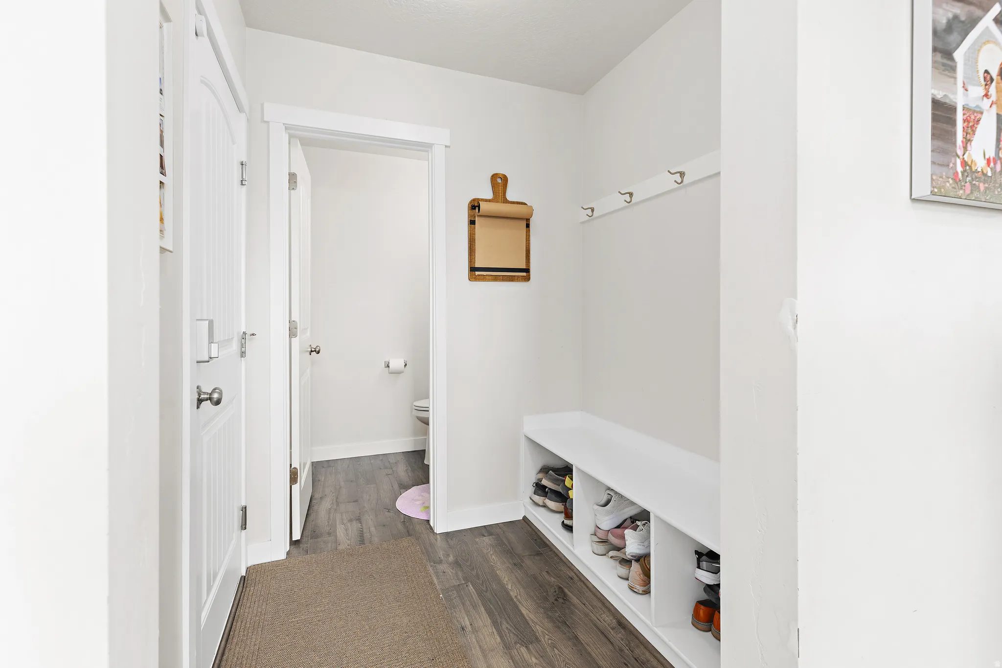 Mudroom with dark wood finished floors and baseboards