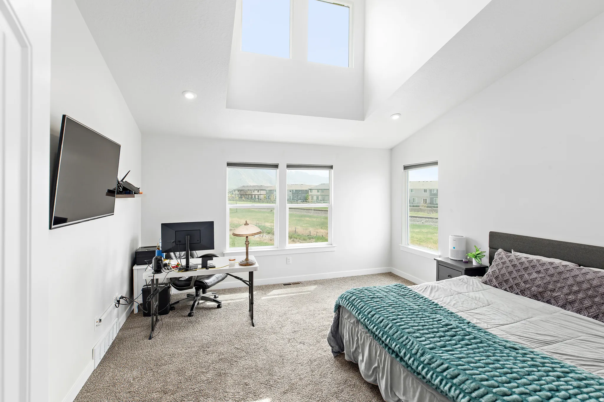 Bedroom featuring an office area, light colored carpet, lofted ceiling, and recessed lighting