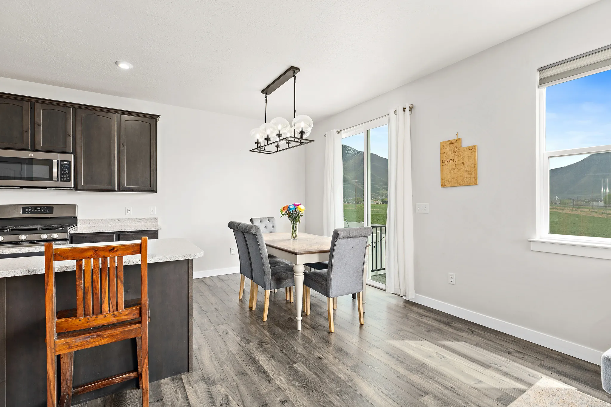 Dining space with a mountain view, dark wood-style flooring, and suspended lighting