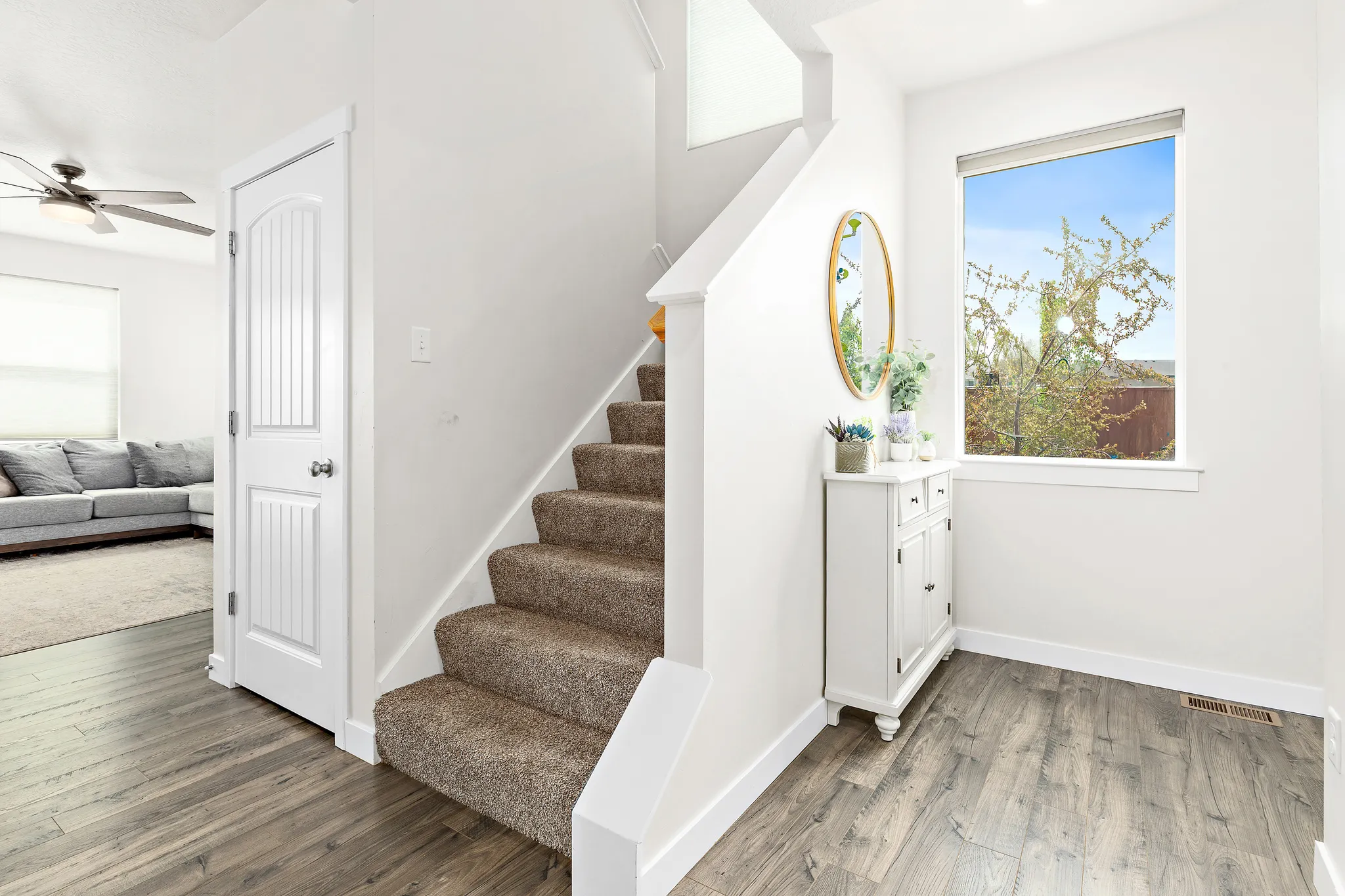 Stairway with wood finished floors and ceiling fan