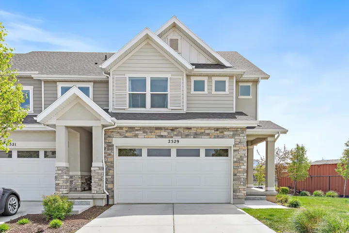 Craftsman house with stone siding, driveway, a garage, board and batten siding, and a shingled roof