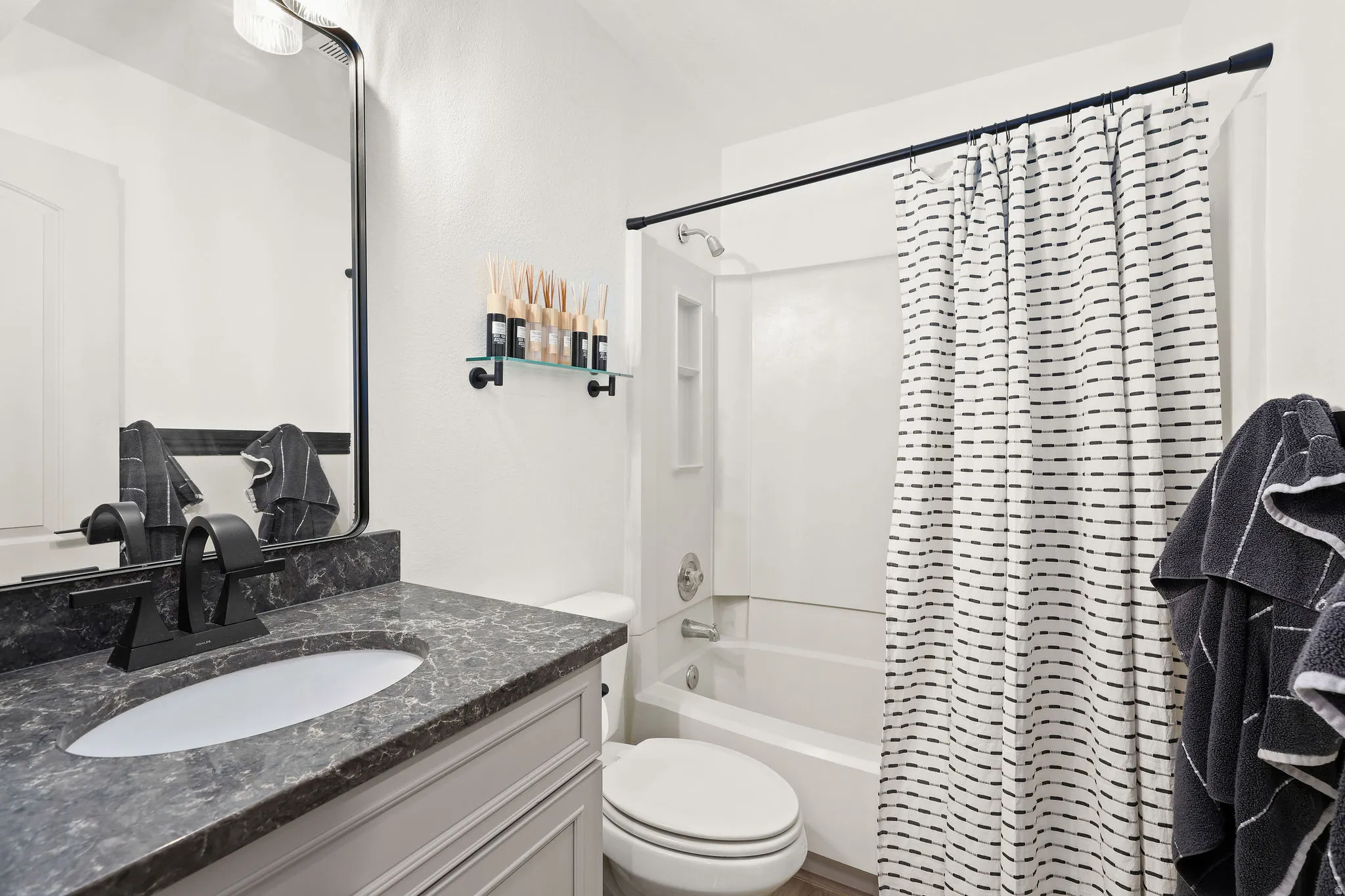 Bathroom with vanity and shower / bath combination with curtain