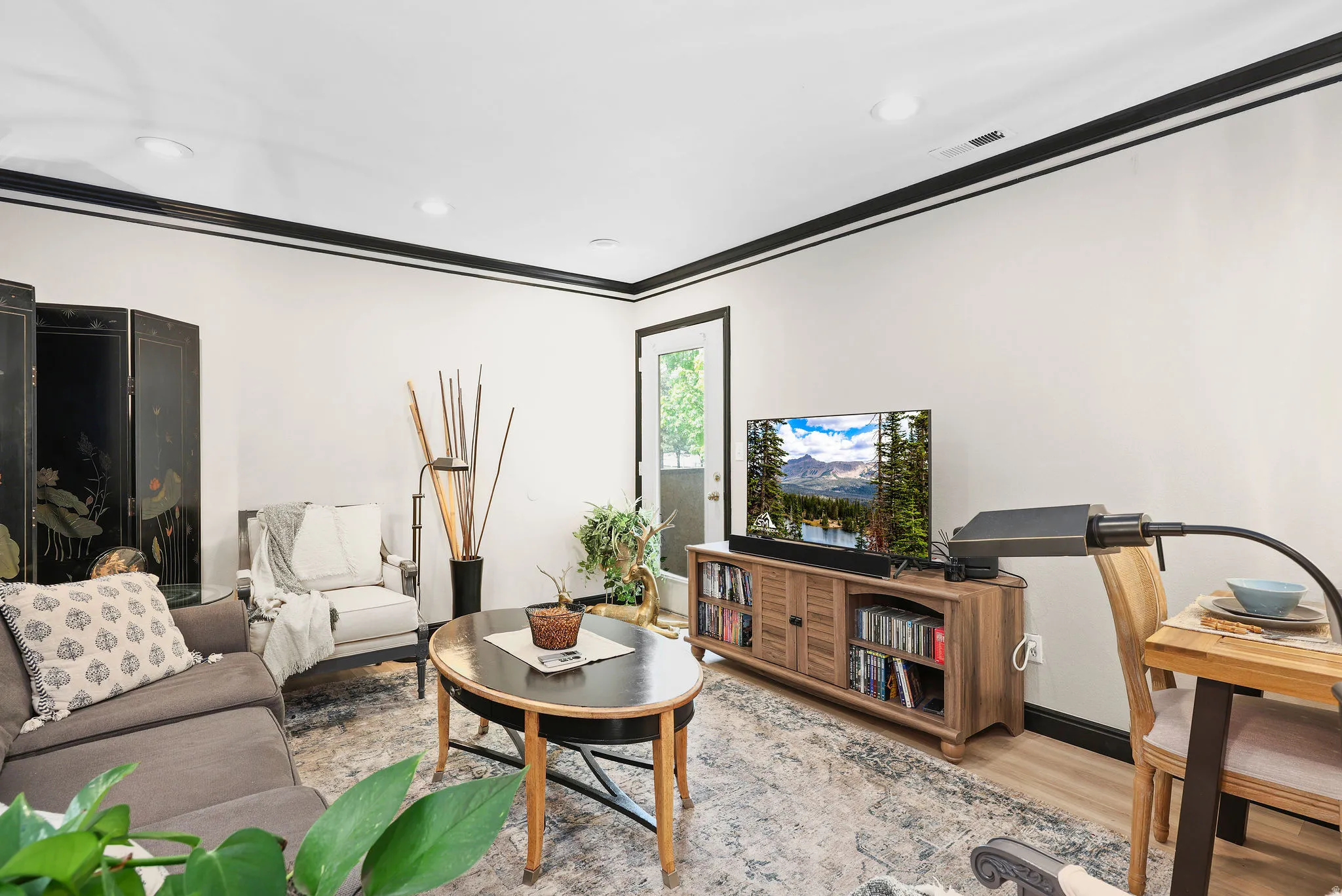 Living area featuring wood finished floors, ornamental molding, and recessed lighting