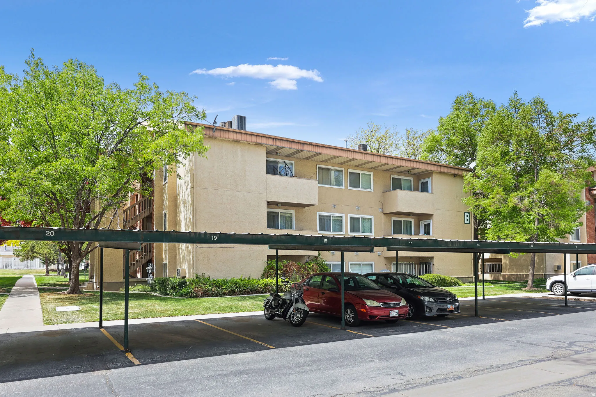 View of apartment building / complex with covered parking