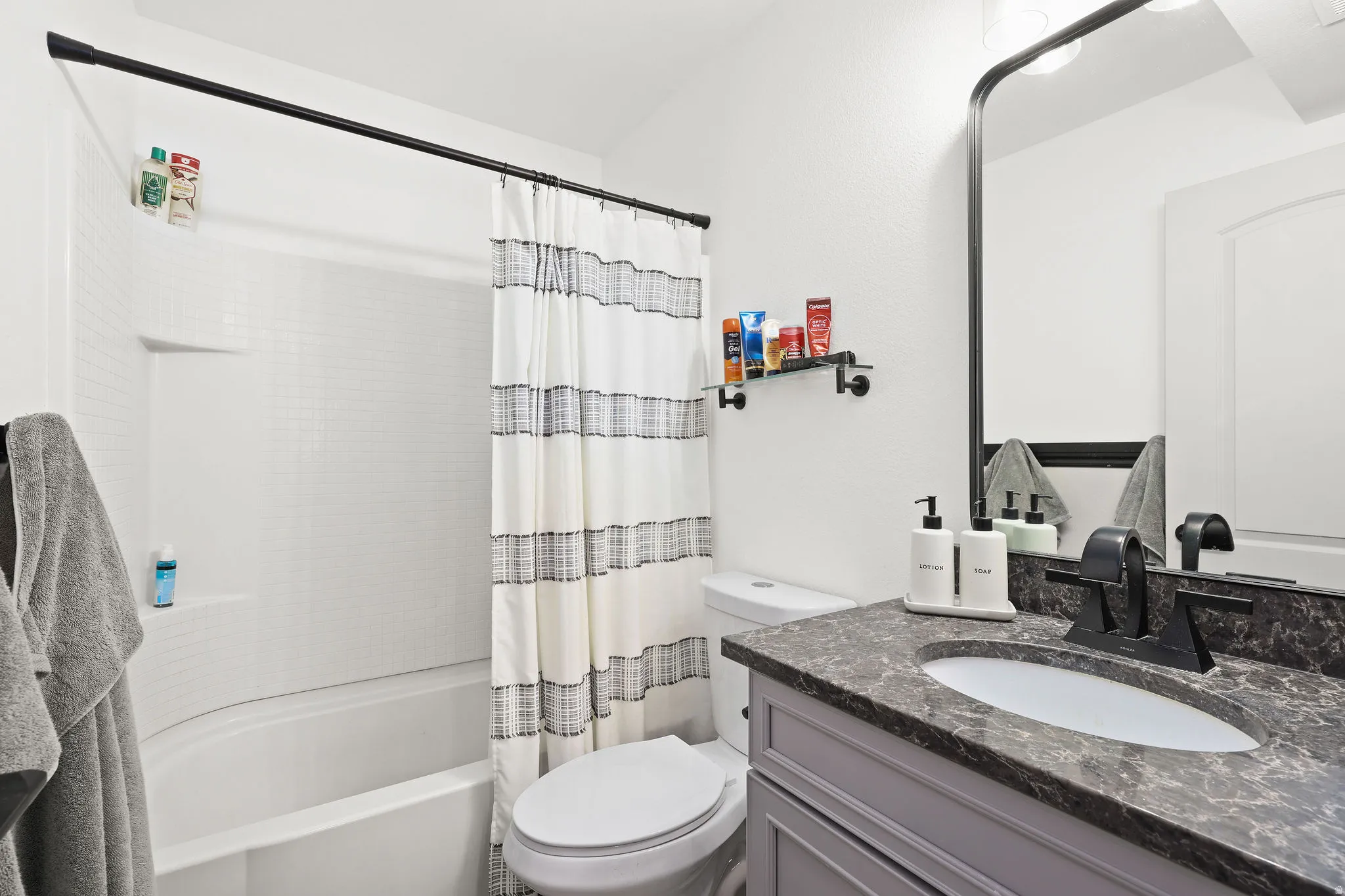Bathroom with vanity and shower / bath combo with shower curtain