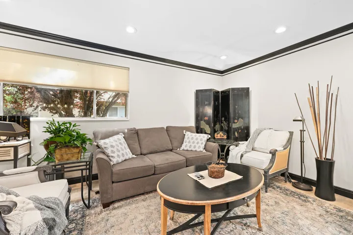 Living room with crown molding, wood finished floors, and recessed lighting