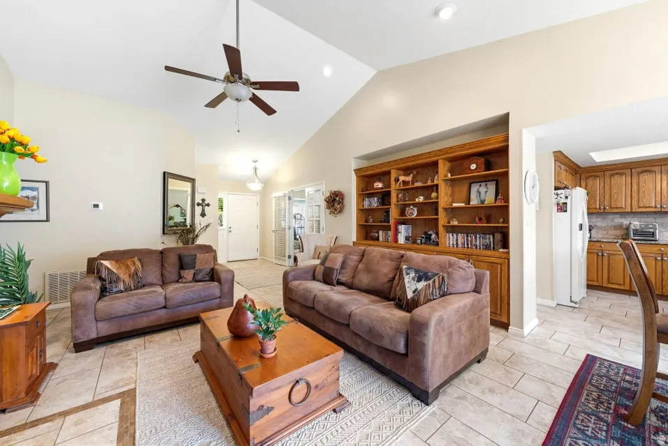 Living area with lofted ceiling and a ceiling fan