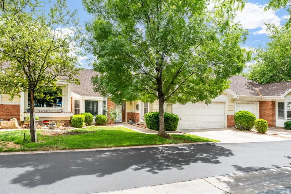Obstructed view of property featuring roof with shingles, brick siding, a garage, concrete driveway, and a front yard