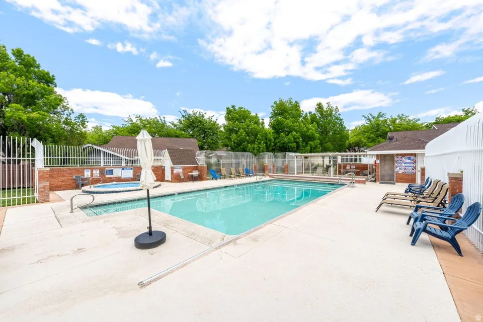Community pool with a patio and a hot tub
