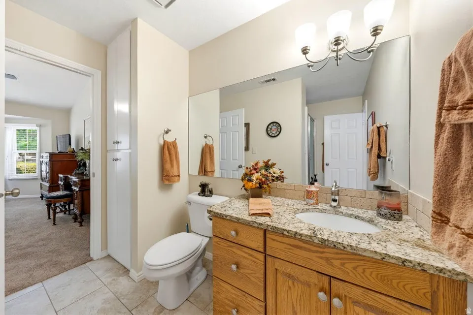 Bathroom featuring vanity, light carpet, light tile patterned flooring, and a shower
