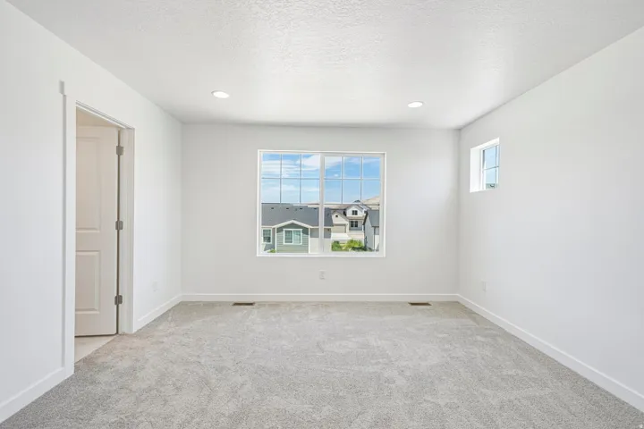 Neutral wall finishes and light gray carpet flooring throughout