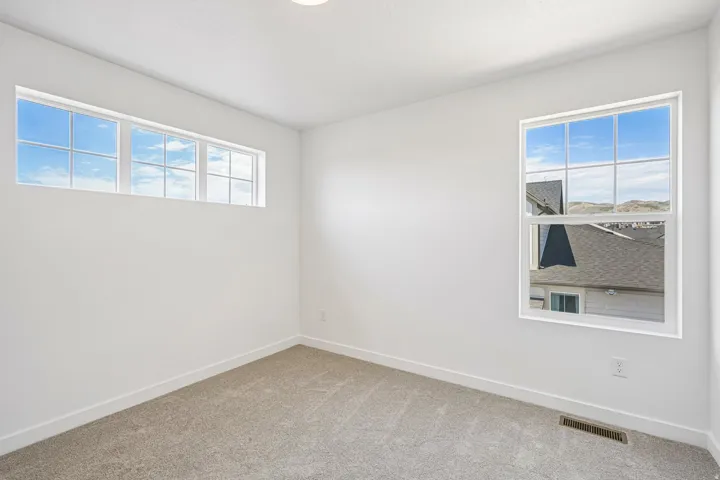 Bright interior space with light gray carpeting, crisp white walls, and white trim