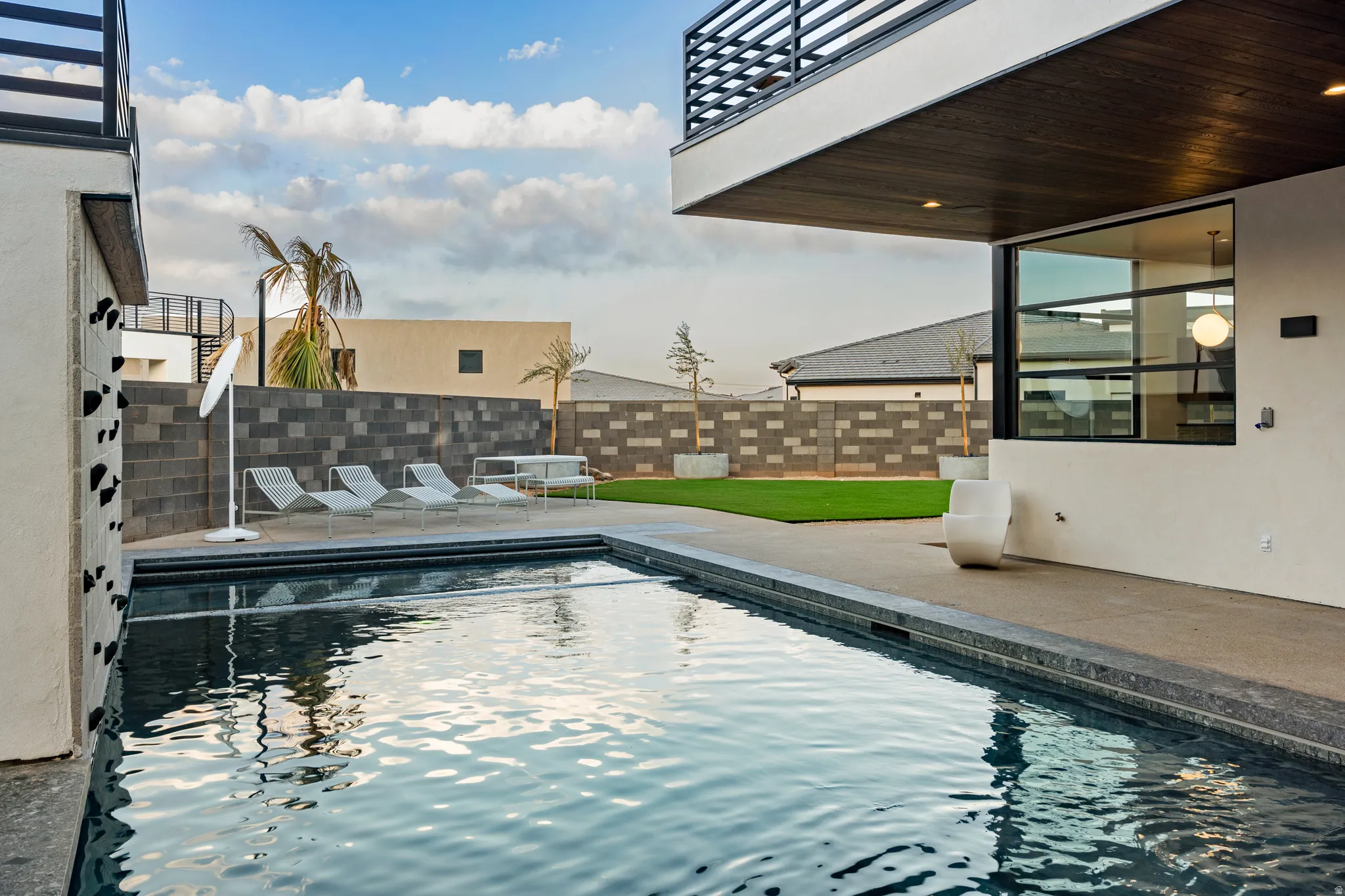 View of swimming pool with patio surround and a fenced backyard