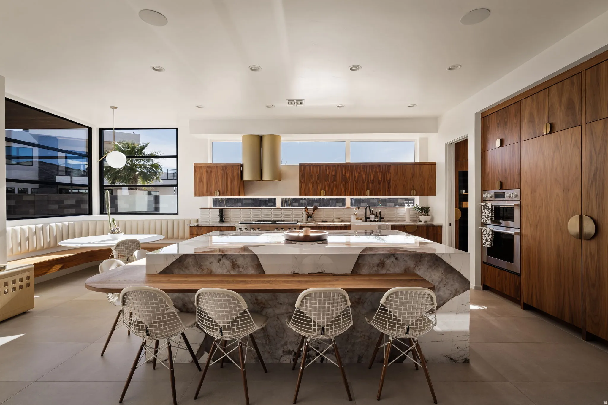 Kitchen featuring modern cabinets, a kitchen bar, light stone counters, and a spacious island