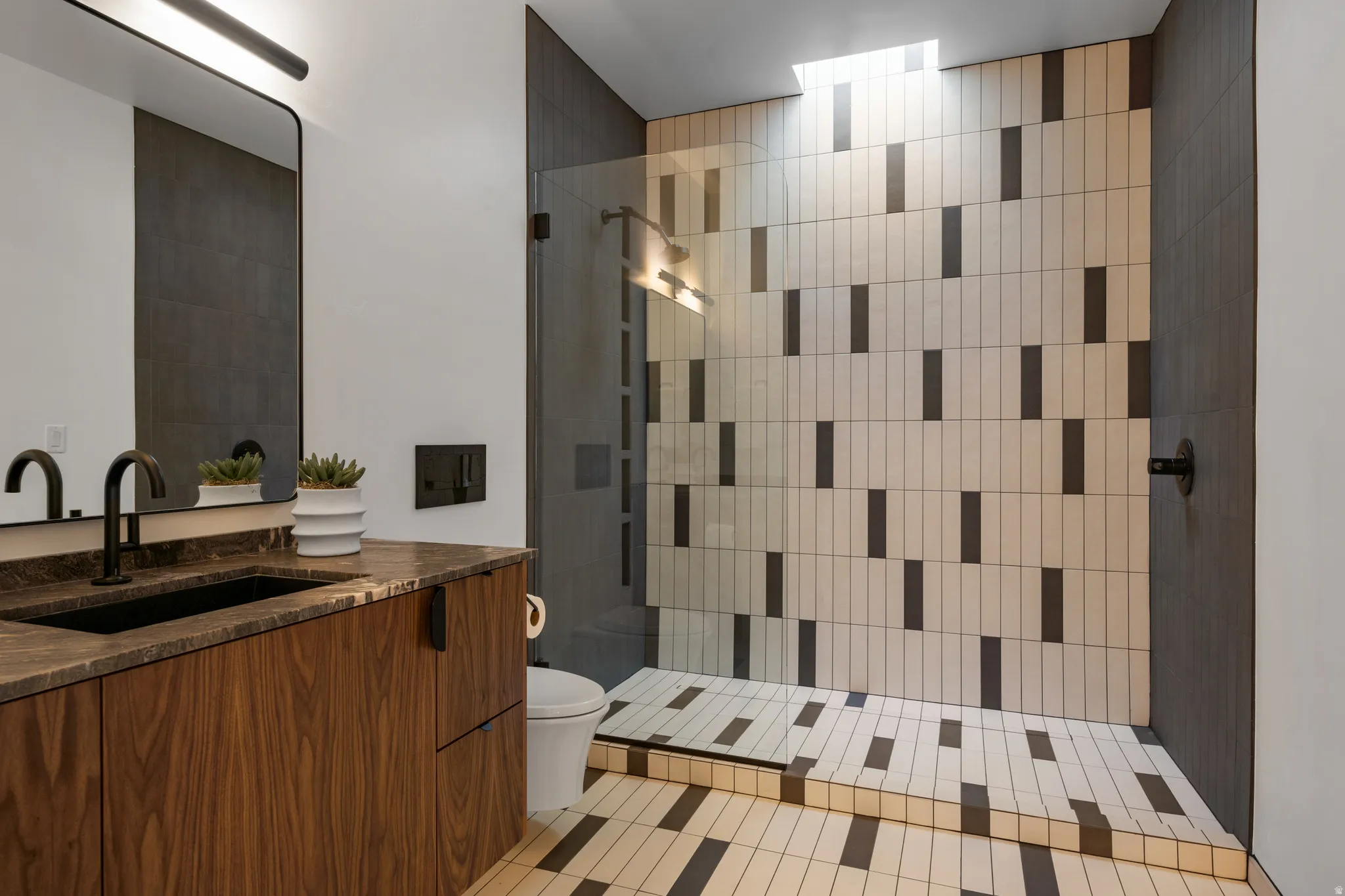 Bathroom with vanity, walk in shower, and light tile patterned flooring