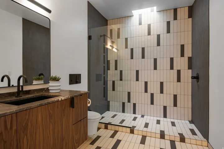 Bathroom with vanity, walk in shower, and light tile patterned flooring