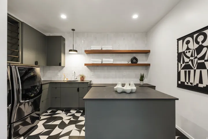 Kitchen with decorative light fixtures, open shelves, gray cabinetry, dark floors, and decorative backsplash