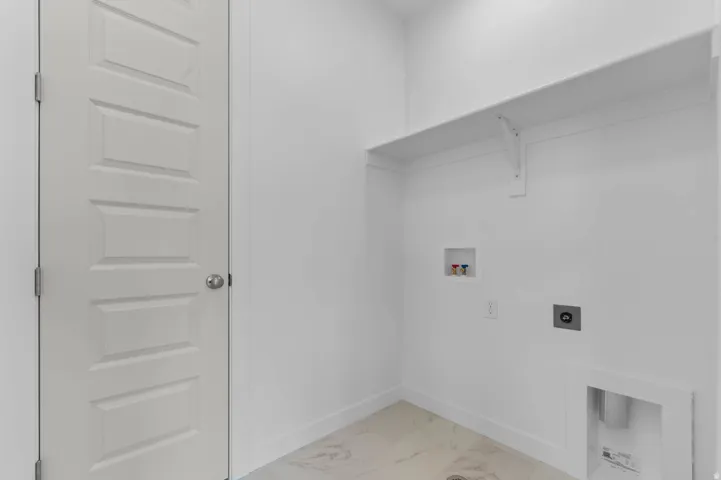Dedicated utility space featuring a neutral color palette, integrated wall shelving, and white baseboards