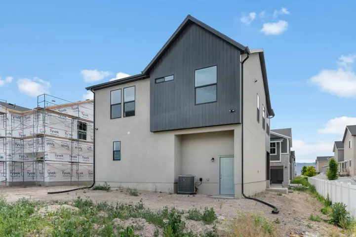 Contemporary two-story exterior featuring a mix of stucco and vertical dark paneling