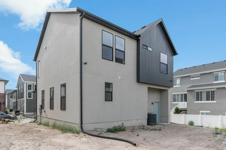 Contemporary exterior featuring light gray stucco and dark gray vertical siding