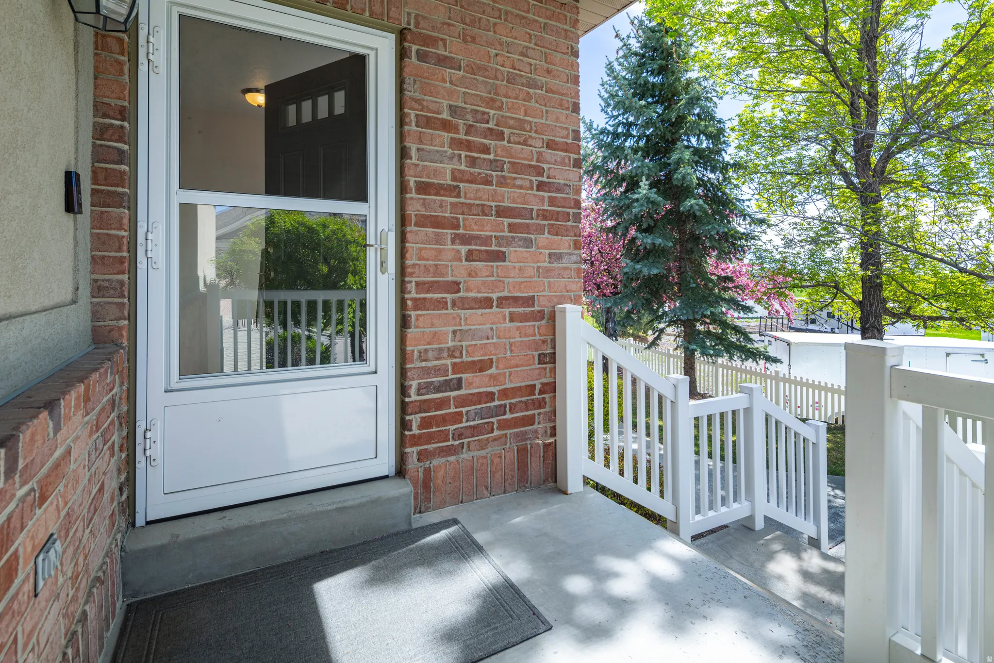 View of exterior entry featuring brick siding and covered porch